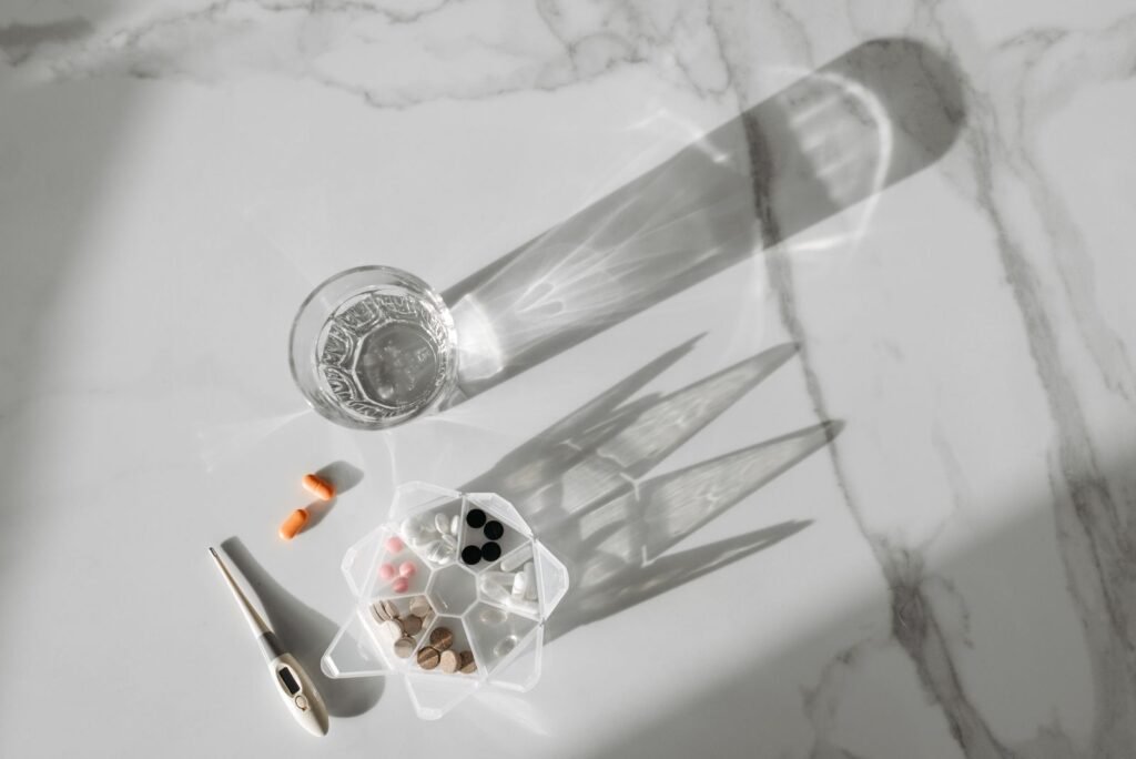 A glass of water and a pill organizer on a table