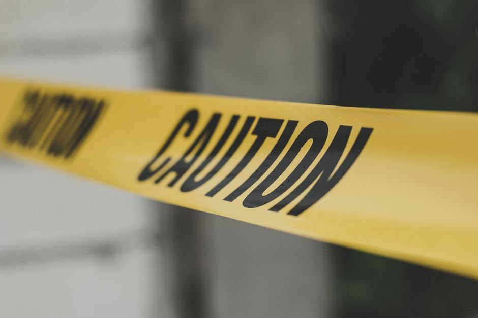 Yellow caution tape stretched across a doorway