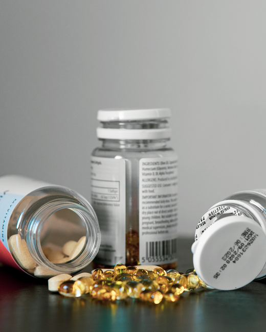 Two medicine bottles with capsules spilled out on a table