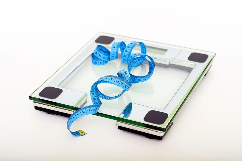Measuring tape coiled on top of a bathroom scale