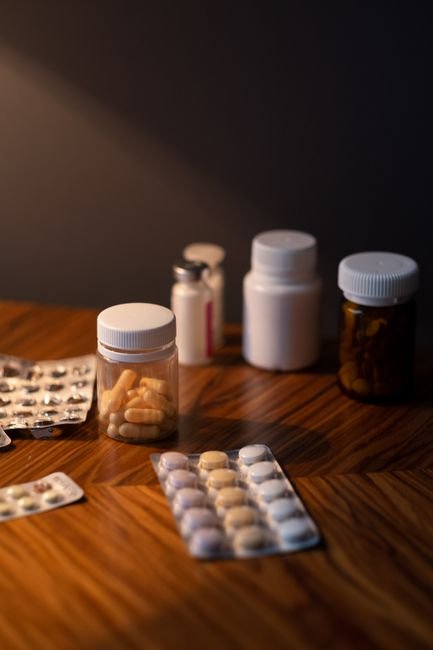 Pill bottles and blister packs of medication on a wooden table